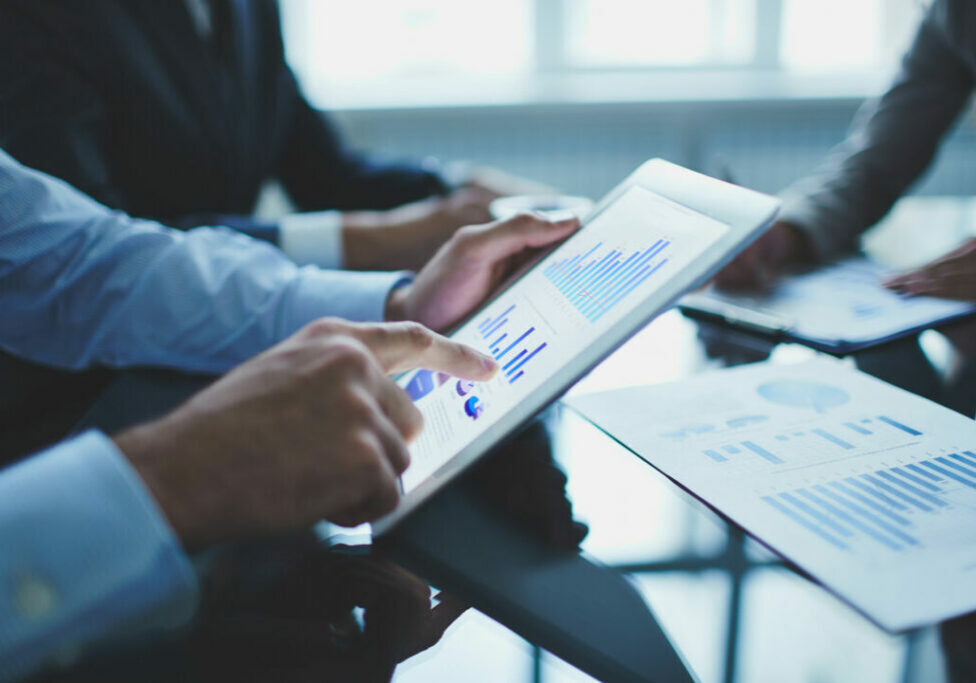 Image of businessperson pointing at document in touchpad at meeting