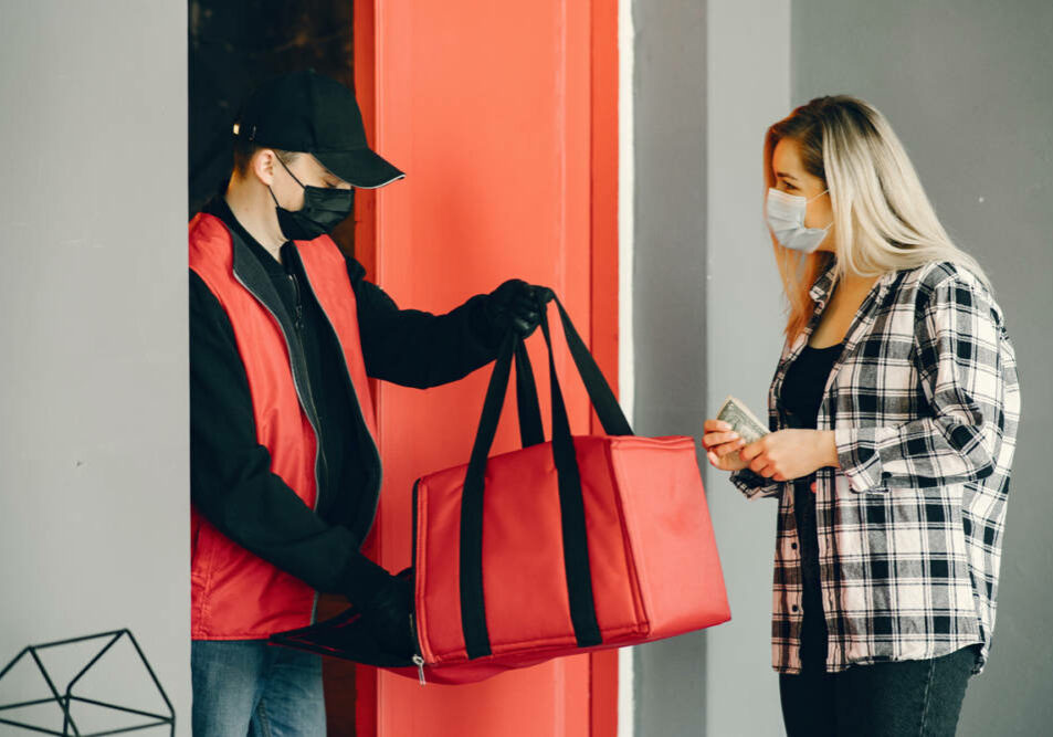 Food delivery during corona virus outbreak. Courier in a face mask. Delivering grocery order in coronavirus epidemic.