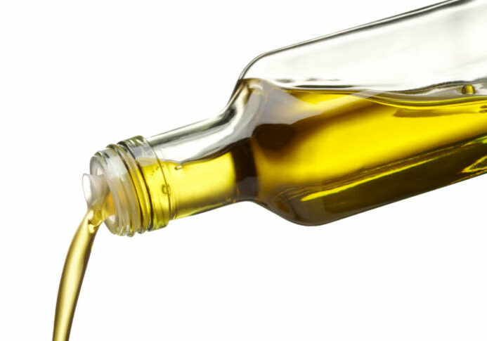 olive oil being poured from glass bottle